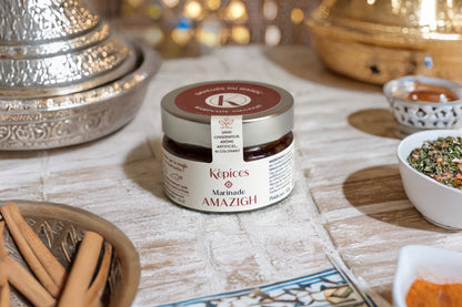 Pot de Marinade Amazigh Képices sur table orientale, accompagné de cannelle, coriandre et paprika.