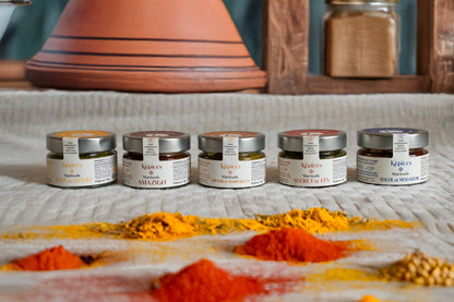 Présentation du Coffret Découverte Képices – cinq marinades marocaines artisanales alignées devant un plat à tajine et des épices en poudre.