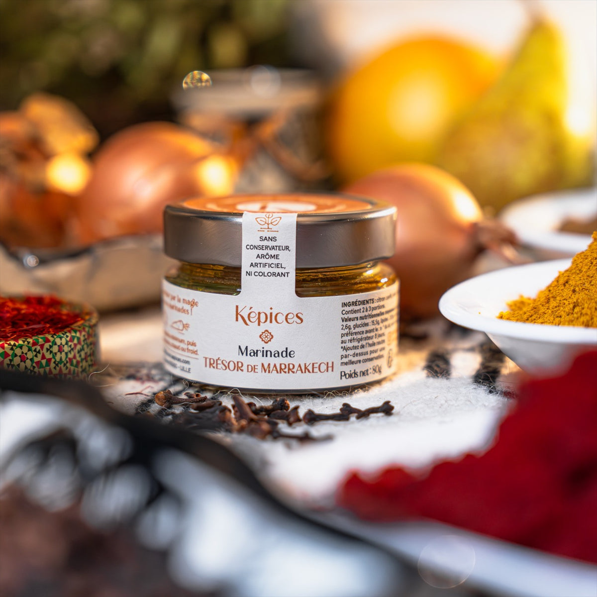 Pot de Marinade Trésor de Marrakech Képices entouré d’épices marocaines colorées, oignons et safran