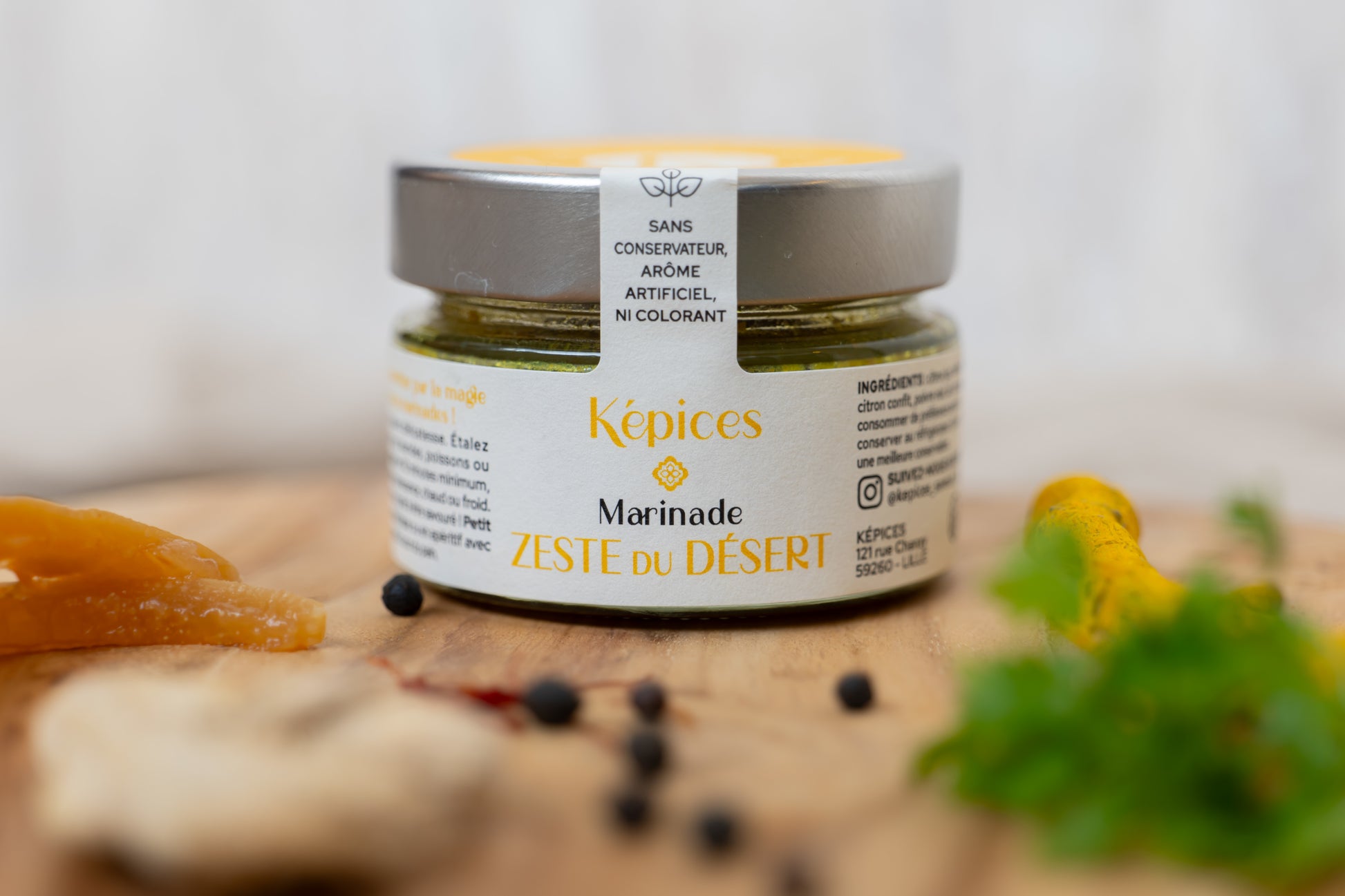 Marinade Zeste du Désert Képices posée sur table orientale, entourée d’épices marocaines et de curcuma.